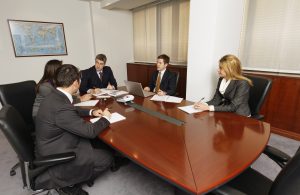 italy office business meeting held indoors at a madium wood table, negotiation techniques in business