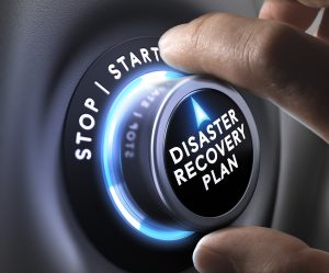 hand turning a dial with disaster recovery plan printed on it